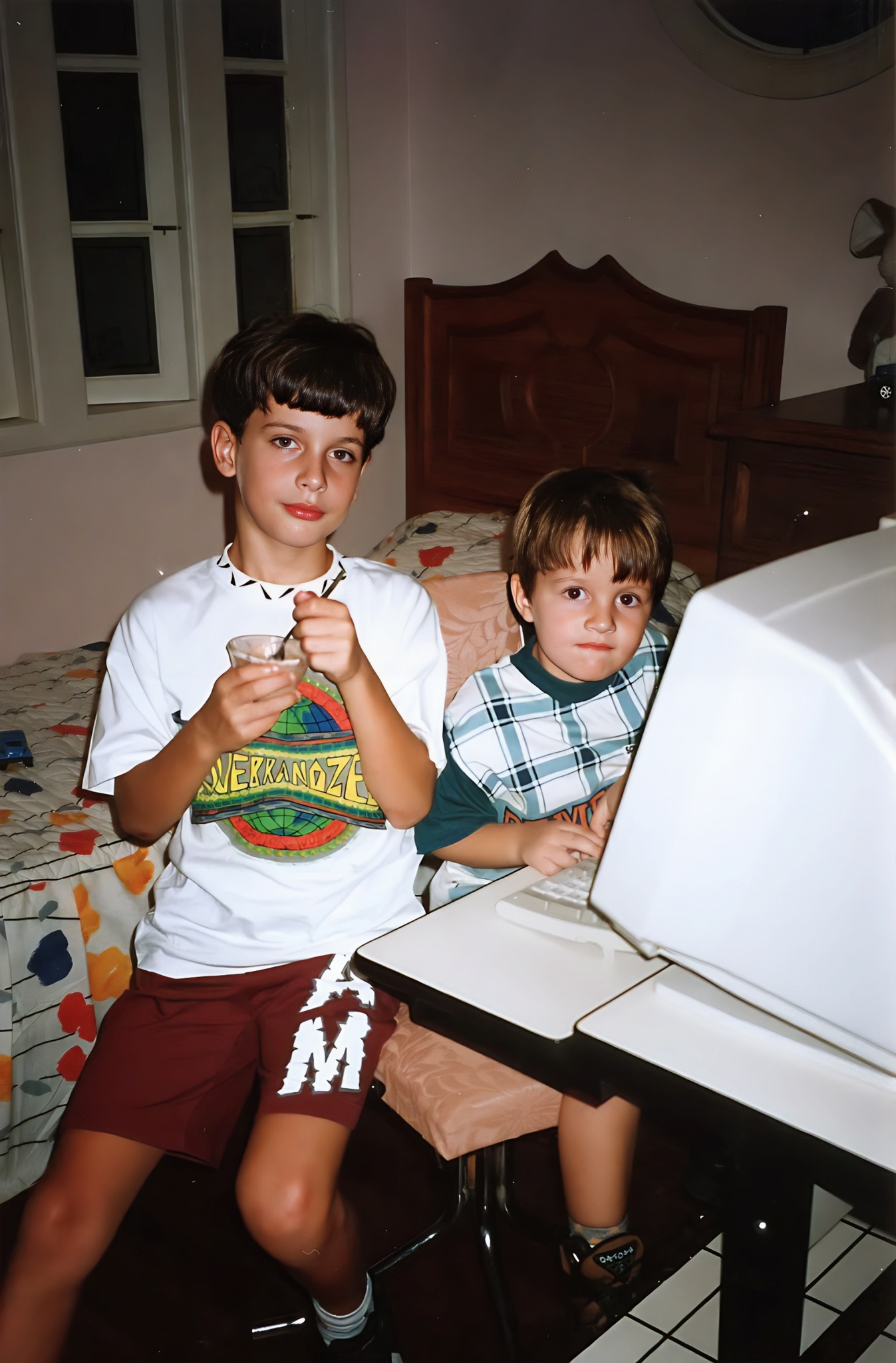 Meu primo e eu ao lado do computador na casa de um tio em 1995